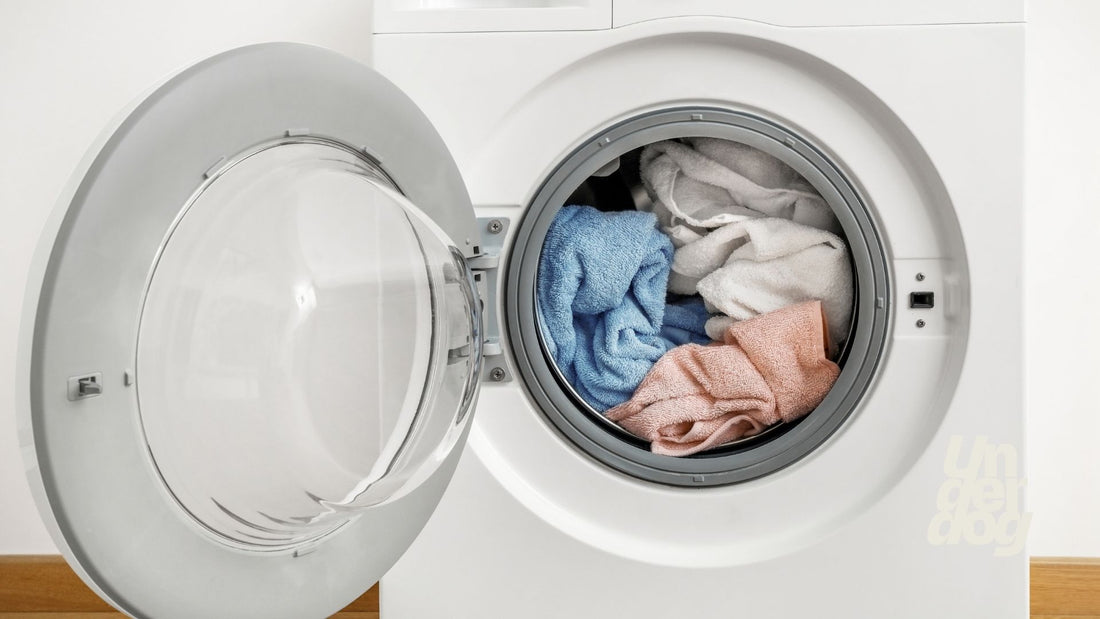 Un sèche-linge rempli de linge avec la porte ouverte.