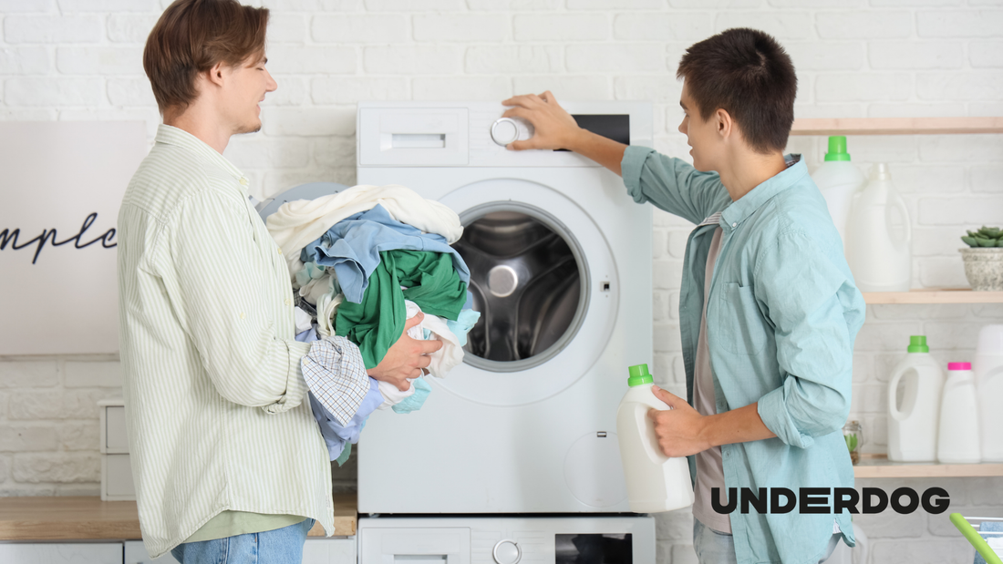 Deux hommes enlèvent le linge de la machine à laver.