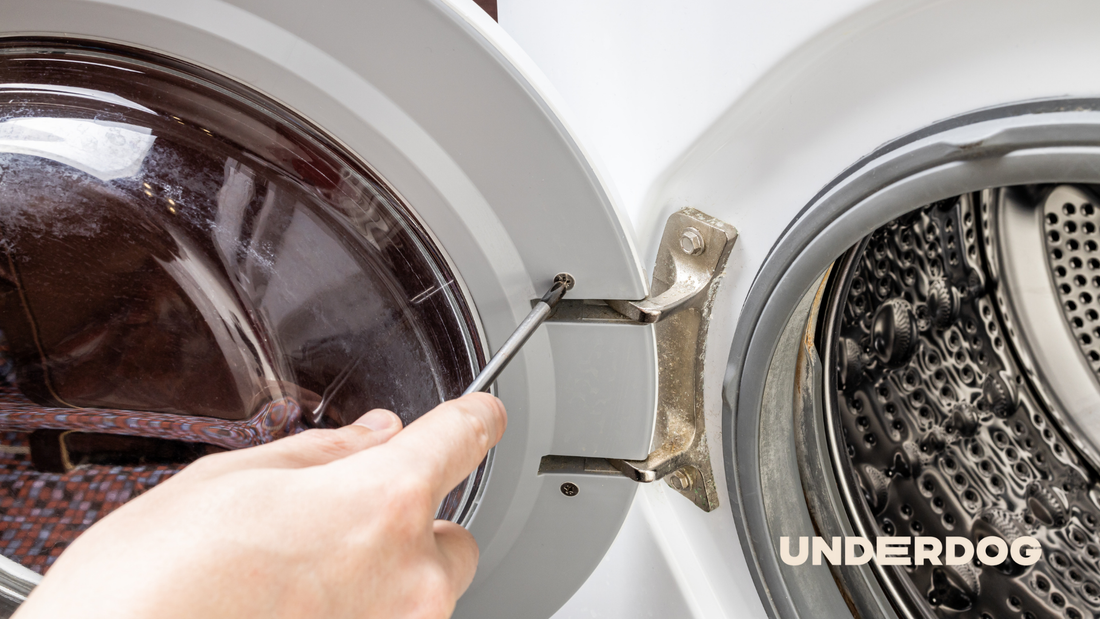 Une personne répare la porte d'un sèche-linge