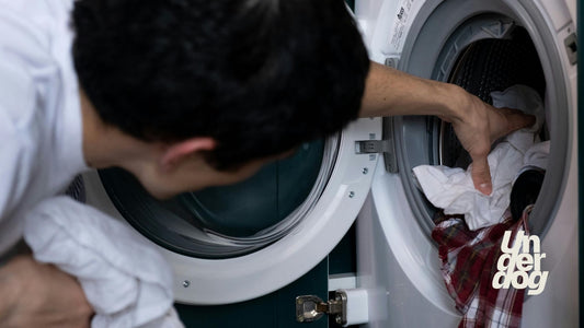 Un homme sort son linge de son lave-linge.