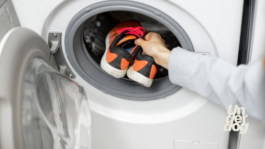 Une femme place des baskets dans le sèche-linge.