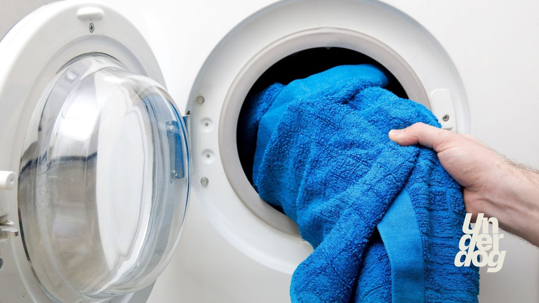 Une personne retire du linge de la machine à laver.