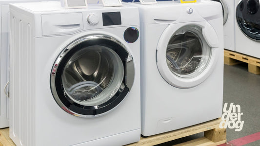 Deux lave-linge neufs posés sur une palette.