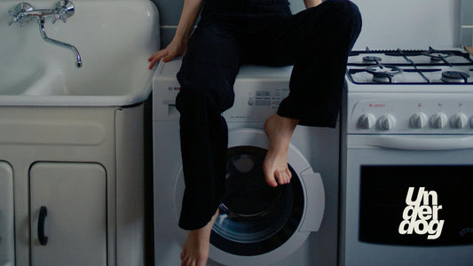 Une personne est assise sur un sèche-linge.