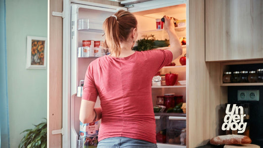 Une femme saisit des aliments dans son réfrigérateur.