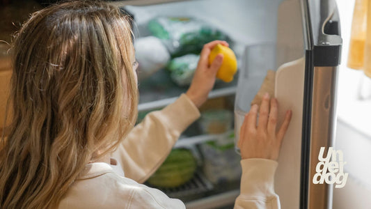 Une femme place un citron dans son réfrigérateur.