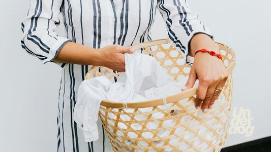 Une personne tenant une corbeille de linge blanc.