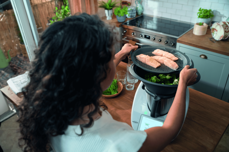 Une femme prépare à manger avec un thermomix TM6