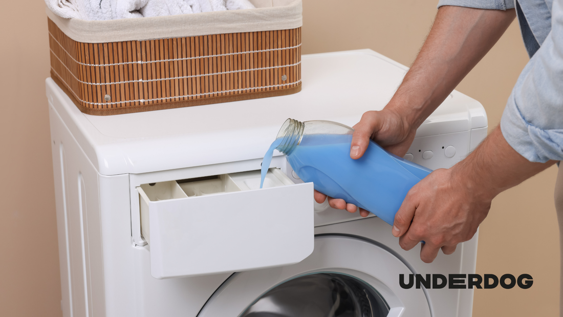 Une personne verse de la lessive dans le bac à lessive d'un lave-linge