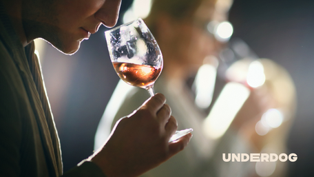 Une personne perçoit l'arôme du vin contenu dans un verre à pied