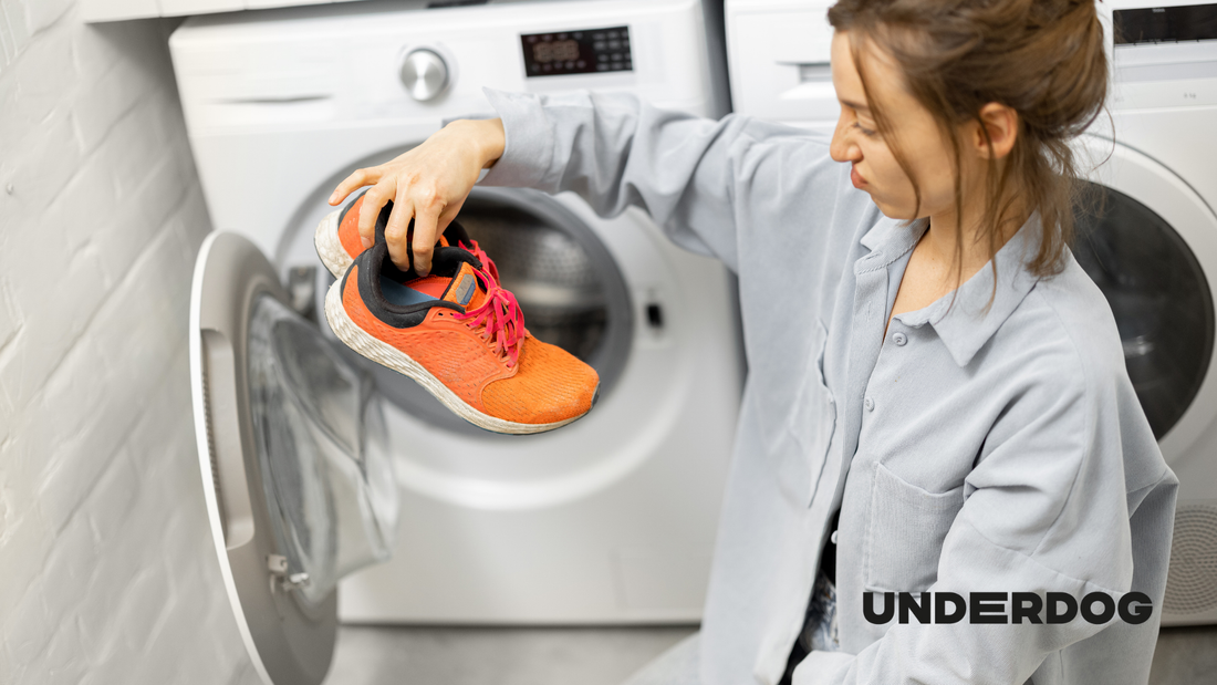Une personne dépose des chaussures de sport dans un lave-linge