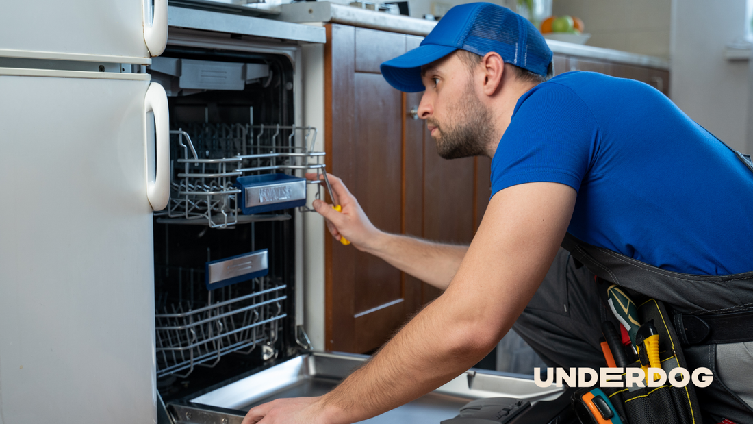 Un technicien répare un lave-vaisselle