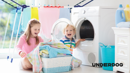 Deux enfants rigolent devant un sèche-linge