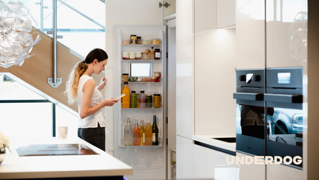 Une femme ouvre un réfrigérateur reconditionné