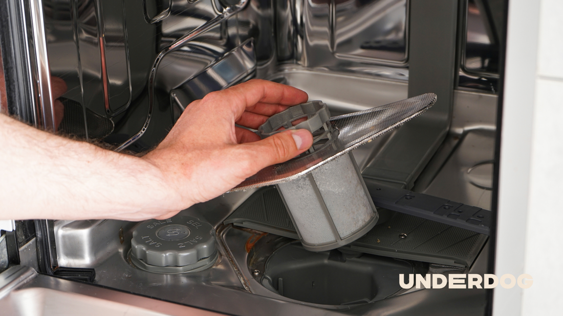 Une personne enlève le filtre du lave-vaisselle