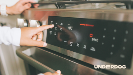 Une personne règle la température d'un four