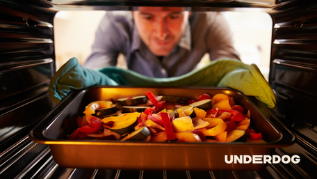 Un homme enfourne un plat dans un four