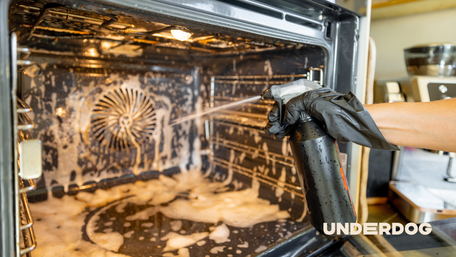 Une personne lave l'intérieur d'un four