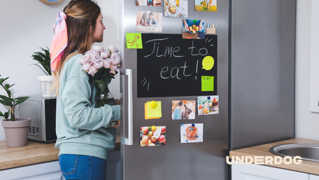 Une personne est devant son réfrigérateur
