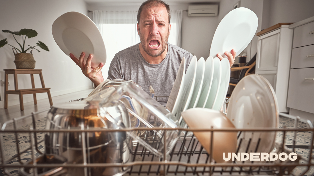 Un homme avec des assiettes dans les mains fait une grimace