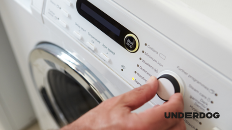 Une personne ajuste les réglages de son lave-linge