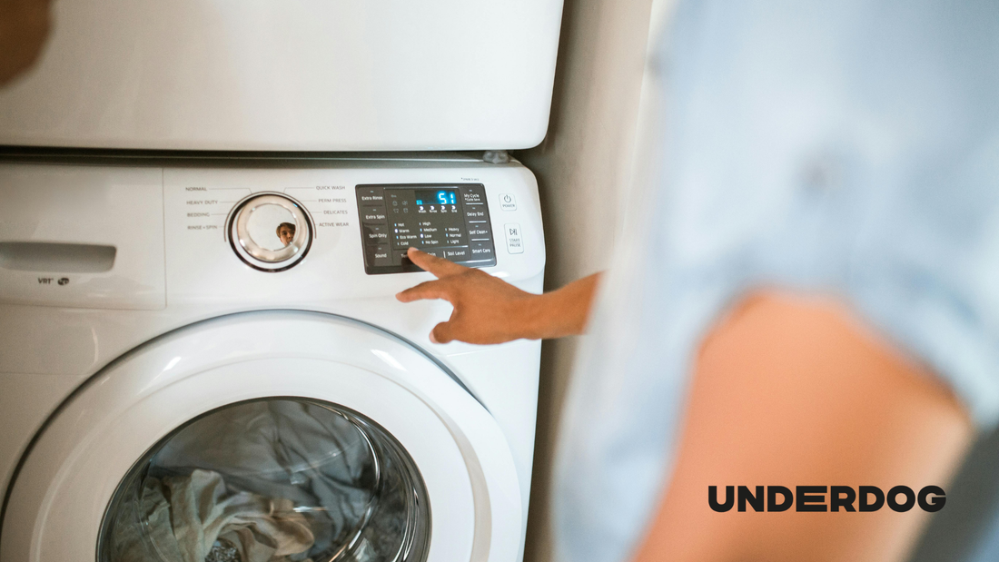 Un homme règle le programme de son lave-linge reconditionné