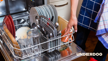 Une personne ouvre un lave-vaisselle remplit