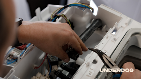 Un technicien répare une machine à laver