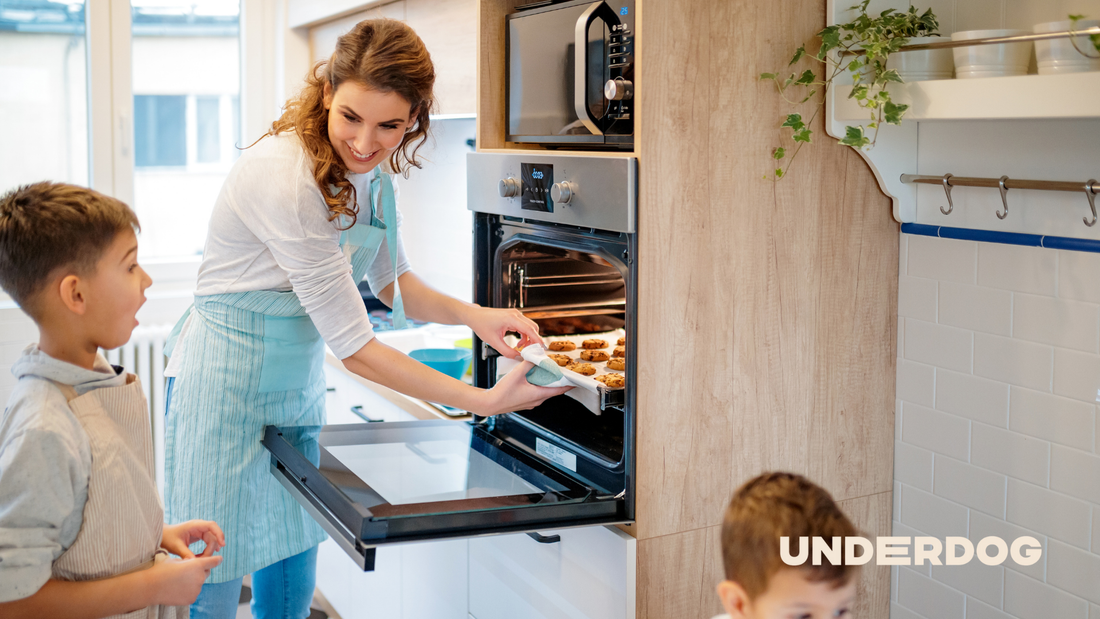 Une femme et ses enfants enfournent un plat au four