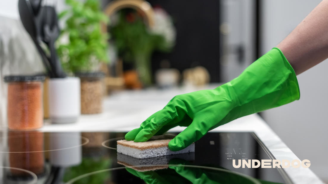 Une personne nettoie une cuisinière à induction avec une éponge