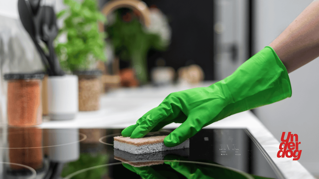 Une personne nettoie une cuisinière à induction avec une éponge