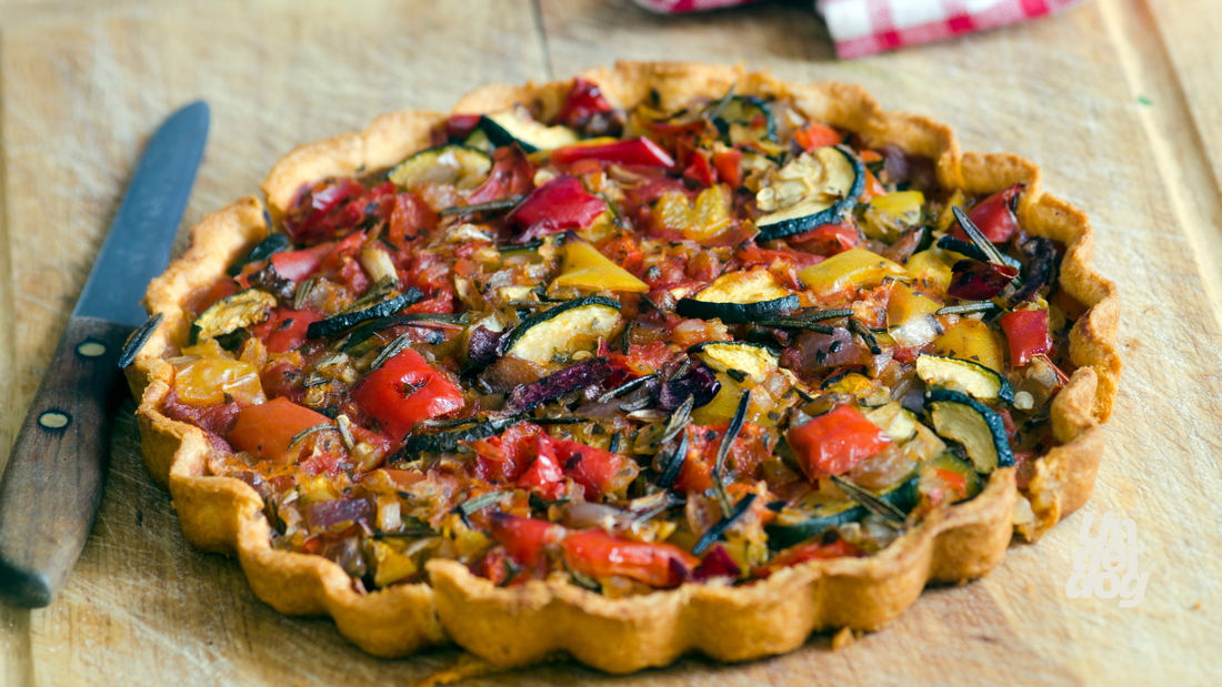 Une tarte aux légumes est posé sur une table à manger.