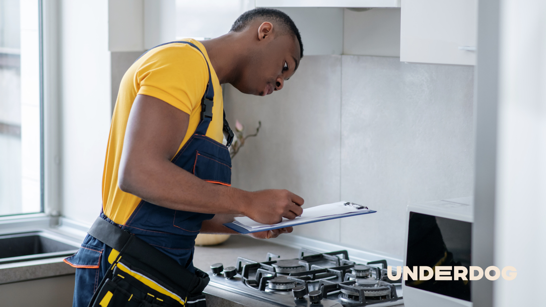 Un technicien effectue le diagnostic d’une cuisinière