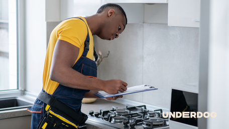 Un technicien effectue le diagnostic d’une cuisinière