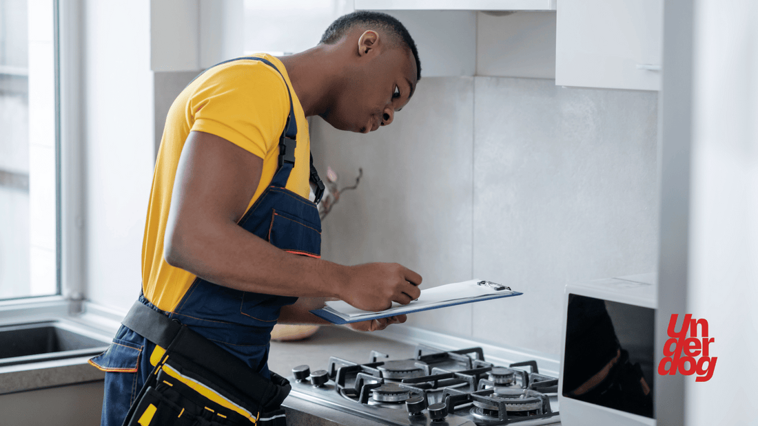 Un technicien effectue le diagnostic d’une cuisinière