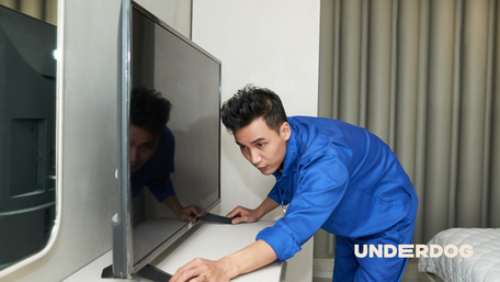 Un homme installe une télévision de 50 pouces dans une chambre