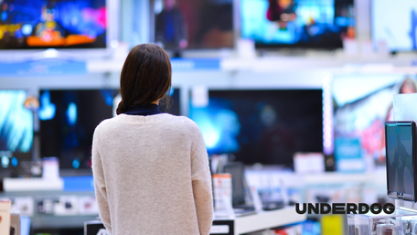Une femme regarde quelle télévision acheter dans un magasin d’électroménager
