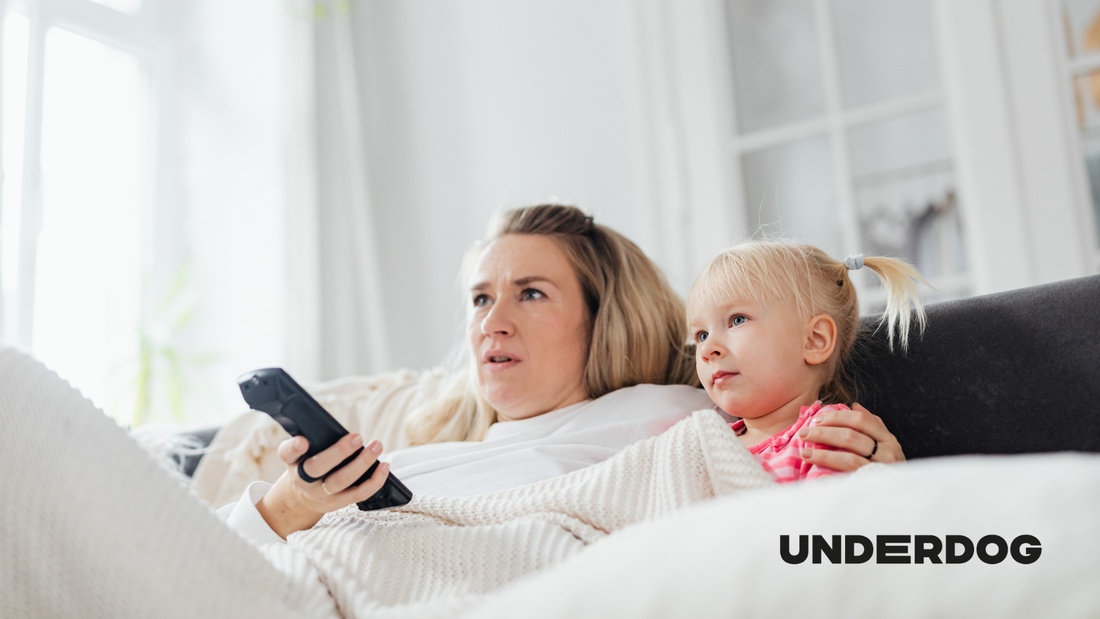 Une mère et sa fille, assises sur un canapé, regardent une télévision connectée