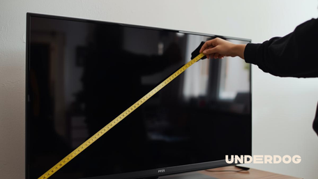 Une personne mesure une télévision de 32 pouces