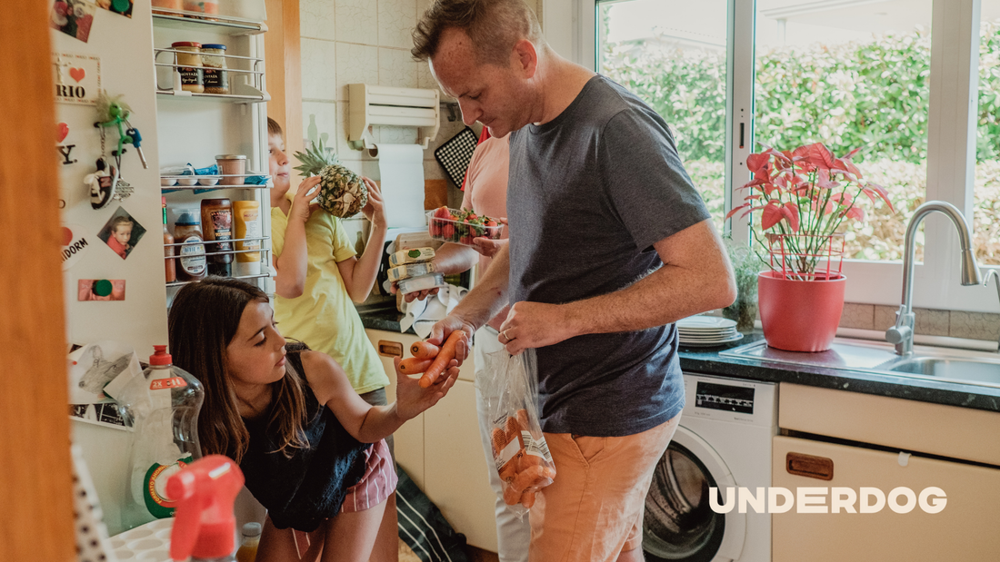 Une famille devant un réfrigérateur dans une cuisine
