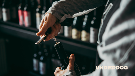 Une personne ouvre une bouteille de vin avec un tire-bouchon