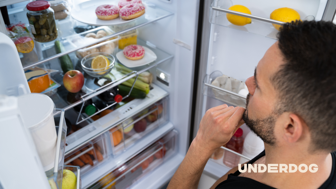 Une personne devant son réfrigérateur