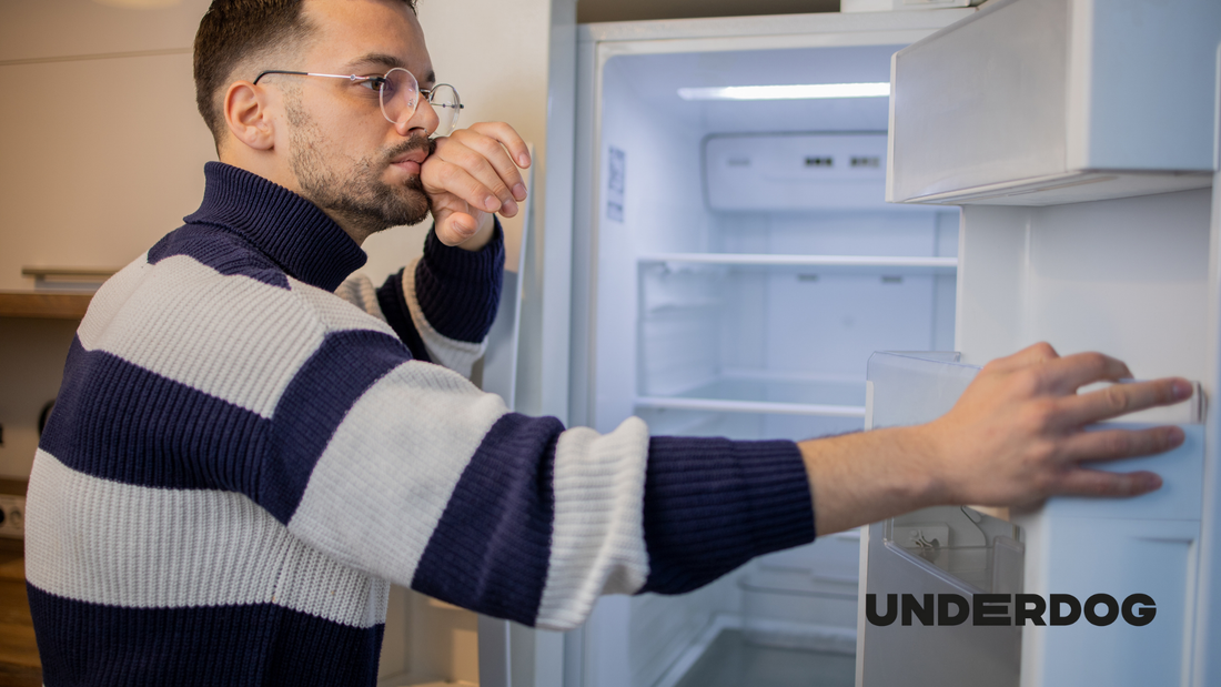 Un homme réfléchit devant son frigo
