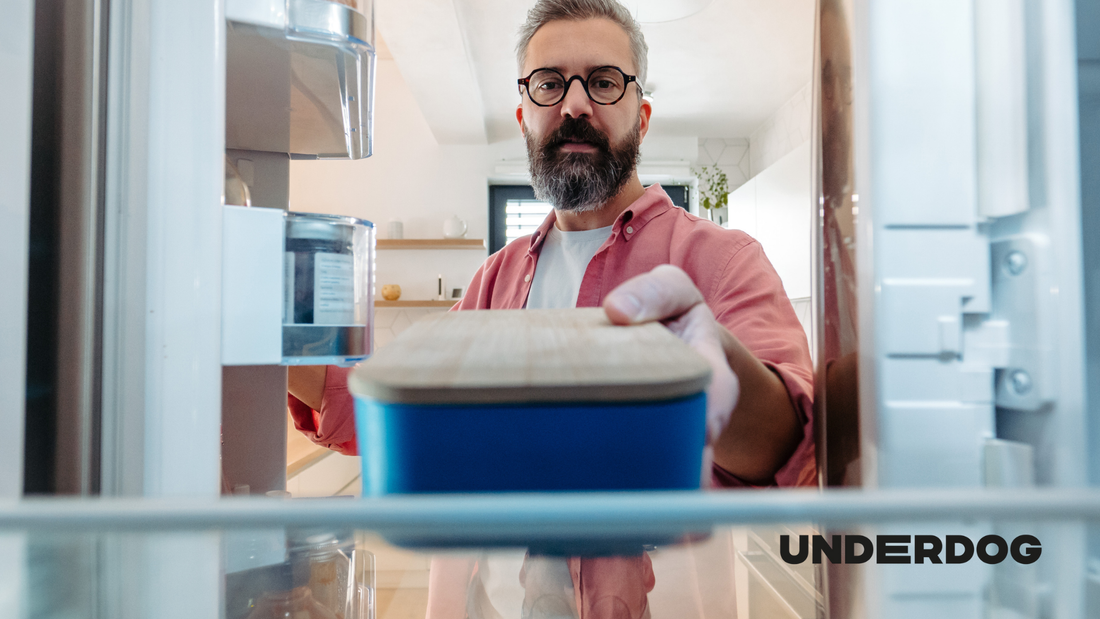 Un homme saisit de la nourriture dans son frigo