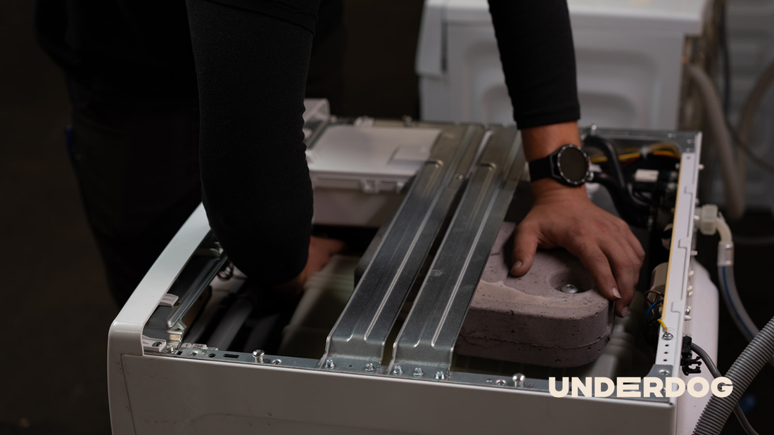 Un technicien reconditionne un lave-linge