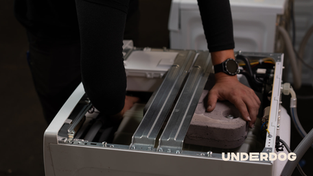 Un technicien reconditionne un lave-linge