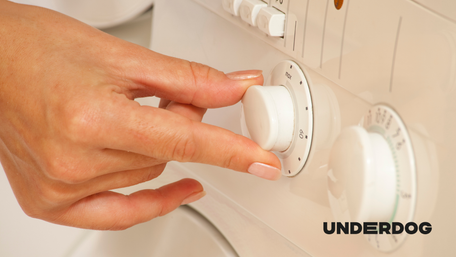 Une main ajuste le bouton de réglage d'un sèche-linge