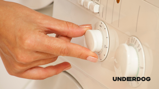 Une main ajuste le bouton de réglage d'un sèche-linge