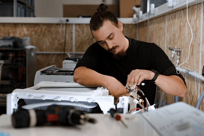 technicien qui répare un lave-linge top