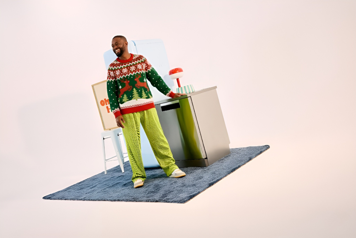 personne en pull de noel devant des appareils électroménagers